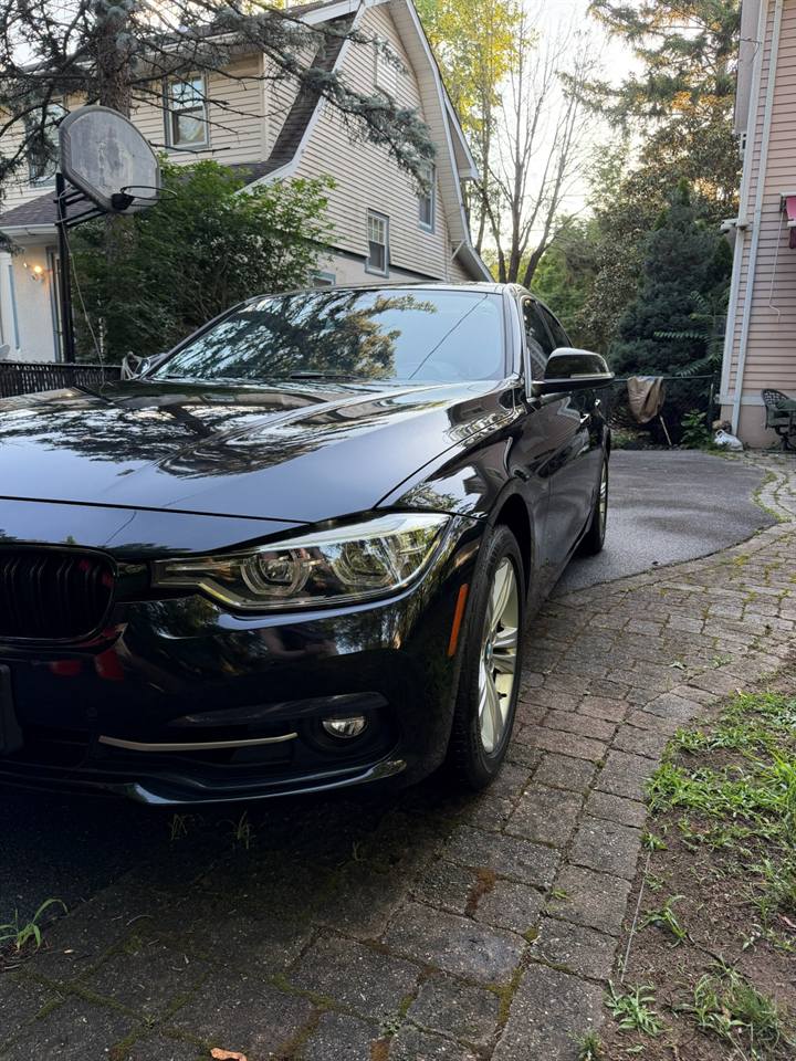 Black BMW shining in a driveway after a mobile hand car wash in Bergen County, NJ